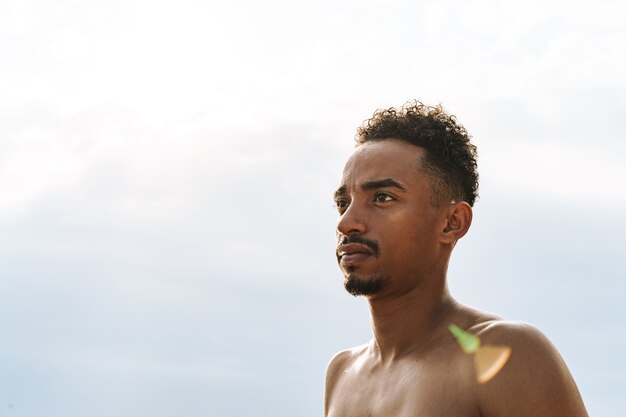 Imagem de um jovem bonito esportes africanos ao ar livre no mar da praia.