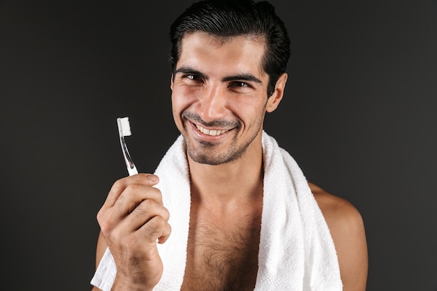 Imagem de um jovem bonito posando escovando isolado, escovando os dentes.