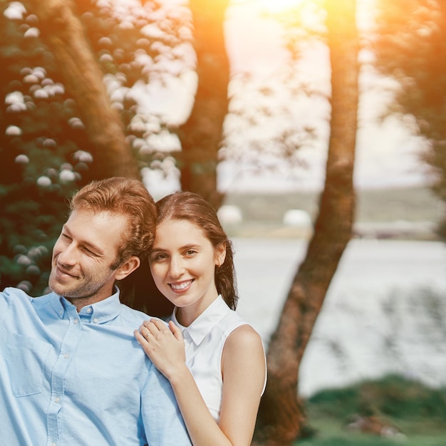 Imagem de um jovem casal em uma caminhada ao longo da margem do lago