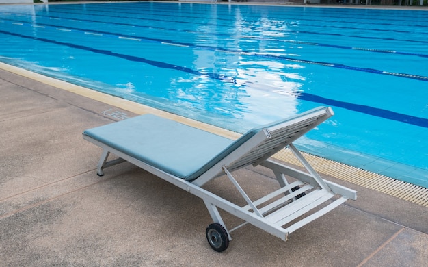 Imagem de uma espreguiçadeira à beira da piscina de um hotel ou resort.