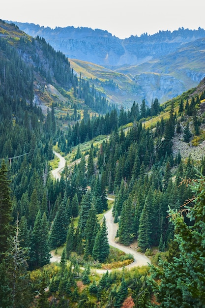 Imagem de uma estrada de terra sinuosa no vale passando pelas montanhas