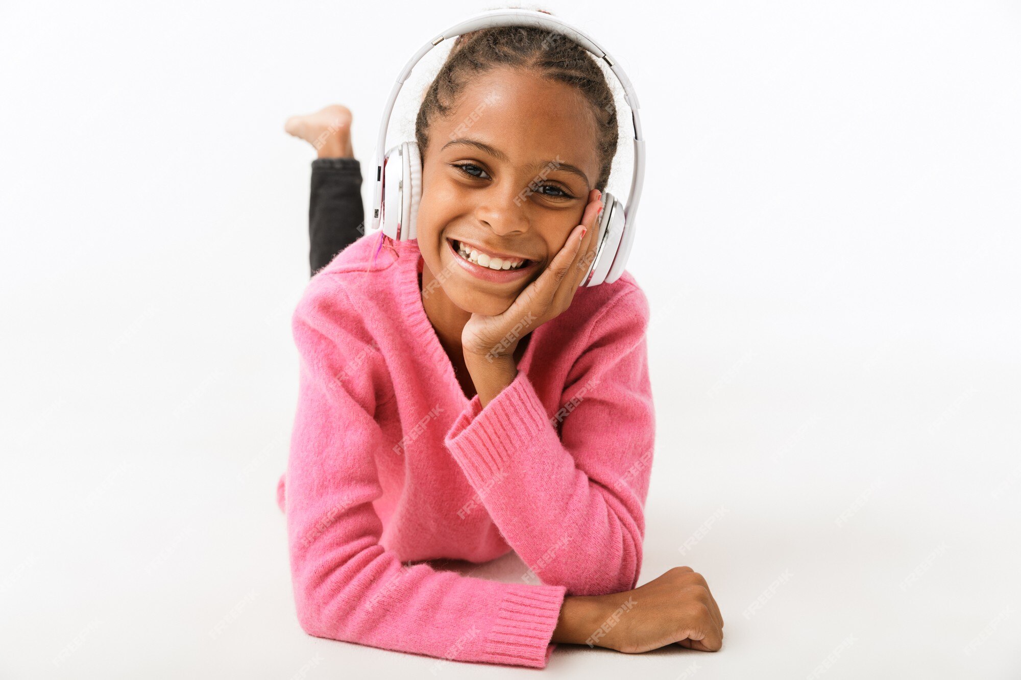 Menina ouvindo música em fones de ouvido na parede rosa. garota