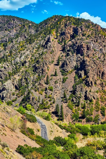 Imagem de uma grande montanha no desfiladeiro com vista de uma pequena estrada pavimentada no deserto