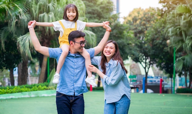 Imagem de uma jovem família asiática brincando juntos no parque