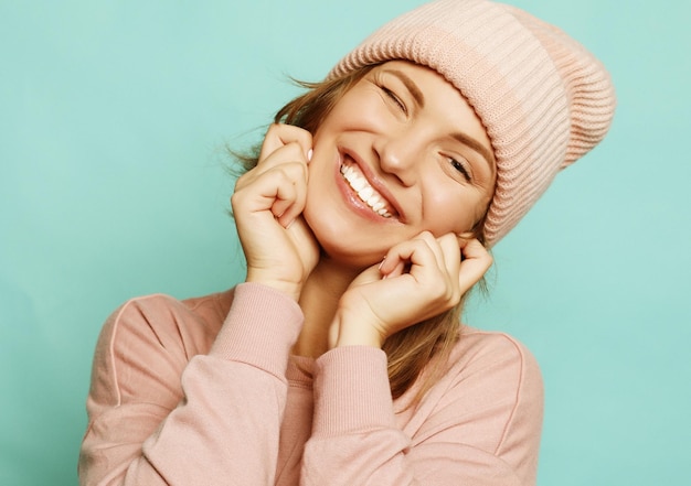 Imagem de uma jovem feliz usando suéter e chapéu rosa