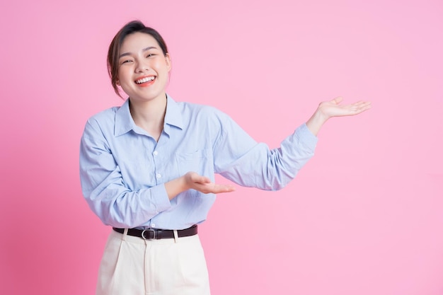 Imagem de uma jovem linda garota asiática posando em fundo rosa