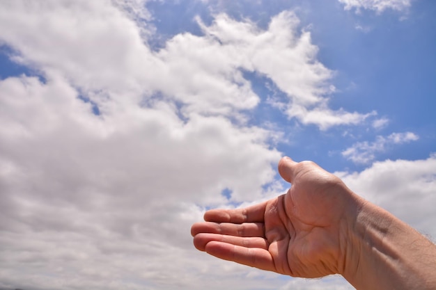 Foto imagem de uma mão sobre um céu nublado