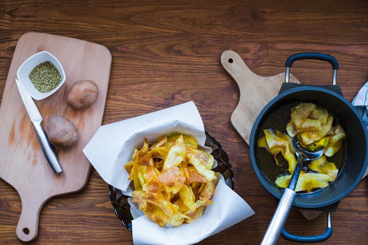 Foto imagem de uma mesa com batatas fritas caseiras preparadas uma tigela com batatas fritas uma panela com óleo quente