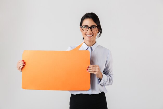 Imagem de uma mulher de escritório satisfeita usando óculos segurando um cartaz amarelo copyspace, isolado sobre uma parede branca