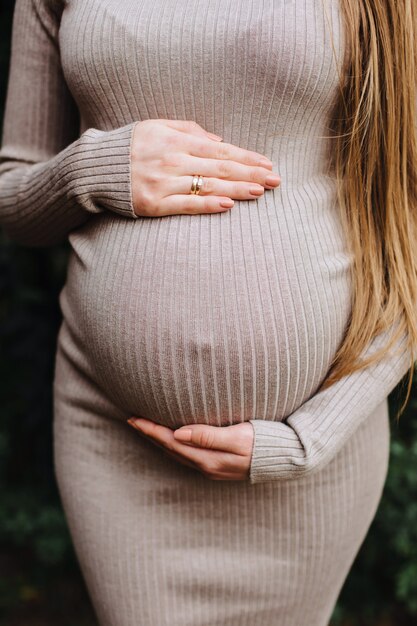 Imagem de uma mulher grávida tocando a barriga com as mãos