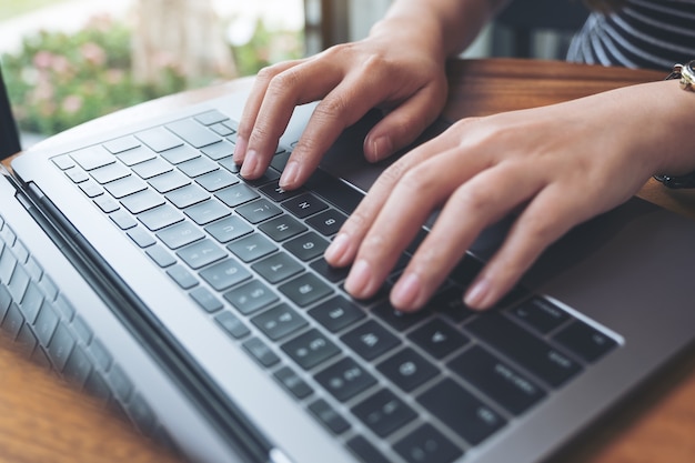 Imagem de vista superior das mãos de uma mulher de negócios, trabalhando e digitando no teclado do laptop