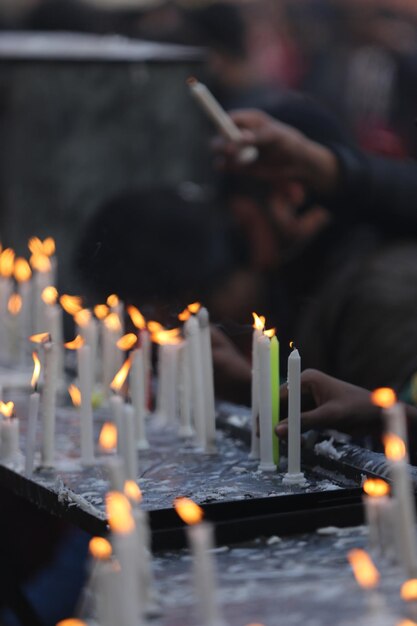 Foto imagem desfocada de um homem segurando velas acesas no templo