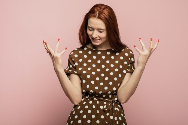 Imagem dinâmica do modelo feminino caucasiano em fundo rosa studio. Vencendo sucesso mulher feliz comemorando ser um vencedor. Vitória, conceito de prazer. Conceito de emoções faciais humanas. Cores da moda