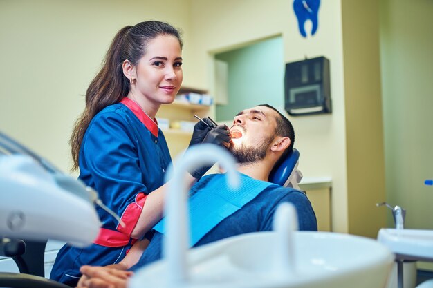 Imagem do dentista usando espelho em ângulo enquanto examina os dentes do paciente