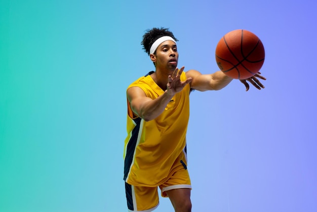 Imagem do jogador de basquete birracial jogando basquete em fundo verde para azul