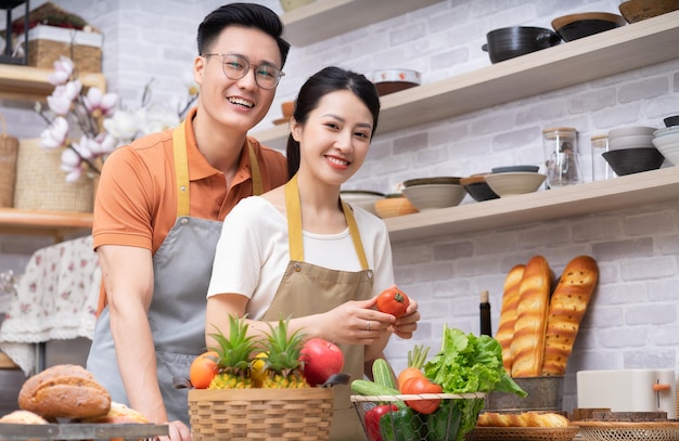 Imagem do jovem casal asiático cozinhando na cozinha