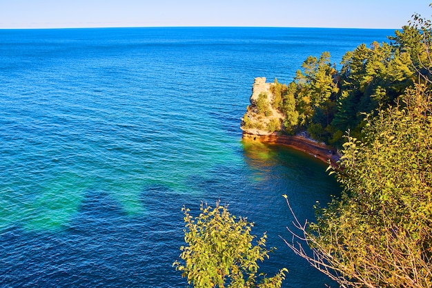 Foto imagem do lago michigan com azul-petróleo profundo e água azul perto de um penhasco de várias cores