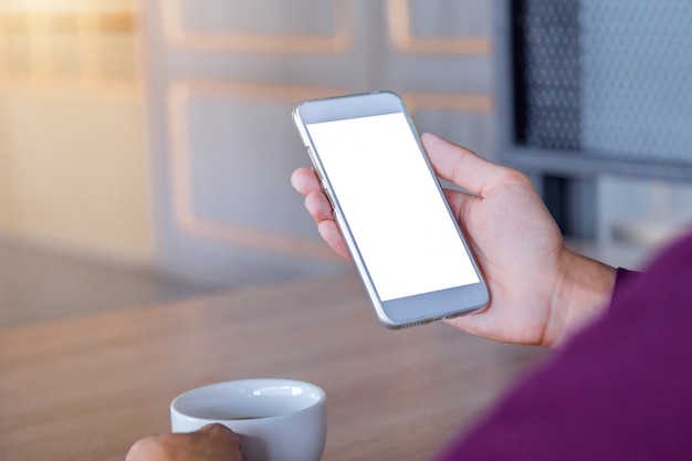 Imagem do modelo das mãos do homem que guardam o telefone celular branco com tecnologia da tela vazia.