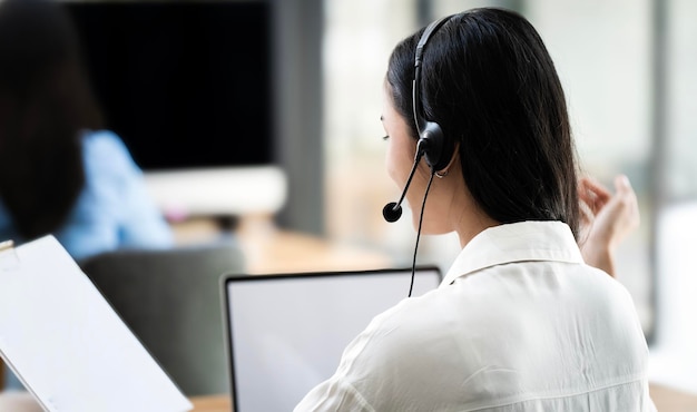 Imagem em close-up de jovem agente de operadora amigável com fones de ouvido trabalhando em um call center