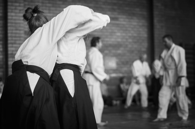 Imagem em preto e branco de meninas atletas de aikido envolvidas na arte marcial do Aikido A forma tradicional de vestuário no Aikido