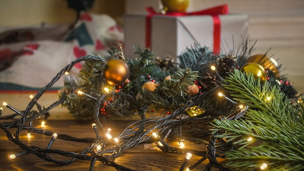 Imagem em tons de close da luz de Natal brilhante no piso de madeira da sala de estar