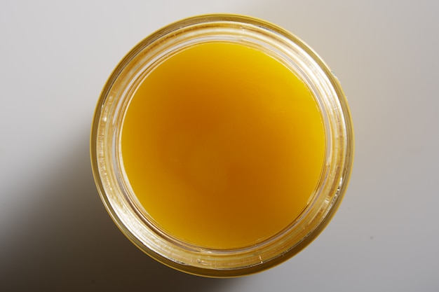 Imagem macro bonita do mel em uma jarra de cima. Apetitosa gota dourada de mel com uma textura texturizada