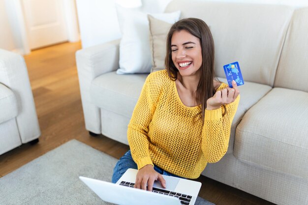 Foto imagem mostrando uma linda mulher fazendo compras on-line com cartão de crédito mulher segurando cartão de crédito e usando laptop conceito de compras on-line