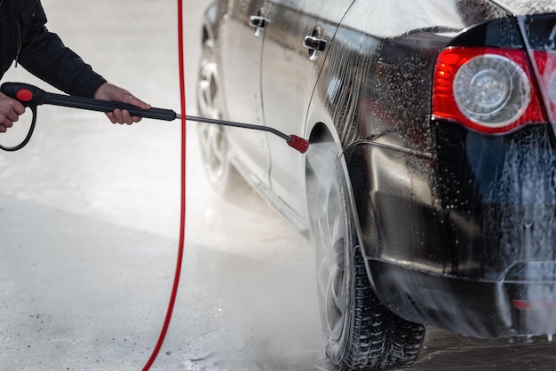 Imagem recortada de homem lavando carro na garagem