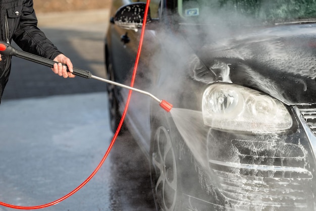 Imagem recortada de homem lavando carro na garagem