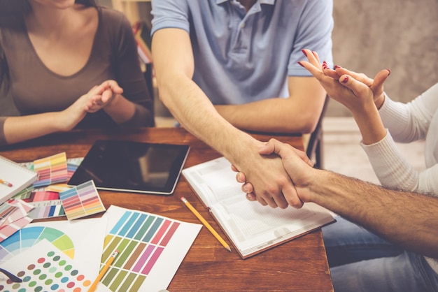 Imagem recortada de jovens designers trabalhando no escritório Homens estão apertando as mãos