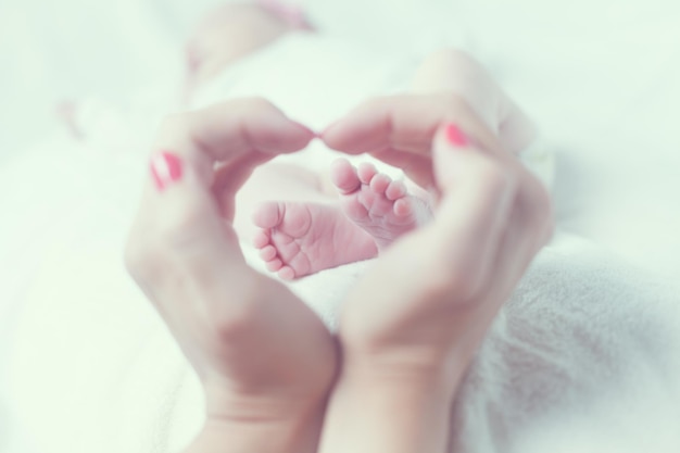 Foto imagem recortada de mãe fazendo forma de coração sobre o bebê