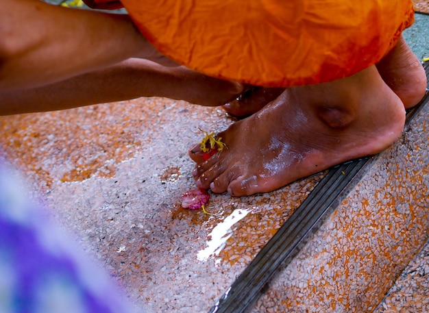 Foto imagem recortada de mão de mulher limpando o pé de monge no templo