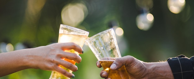 Foto imagem recortada de mão segurando uma garrafa de vinho contra um fundo desfocado