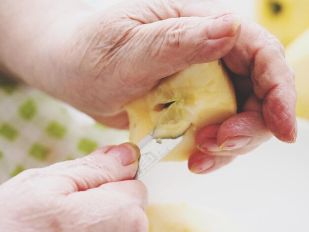 Imagem recortada de mãos cortando frutas