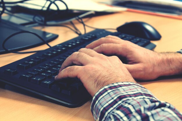 Imagem recortada de mãos digitando no teclado