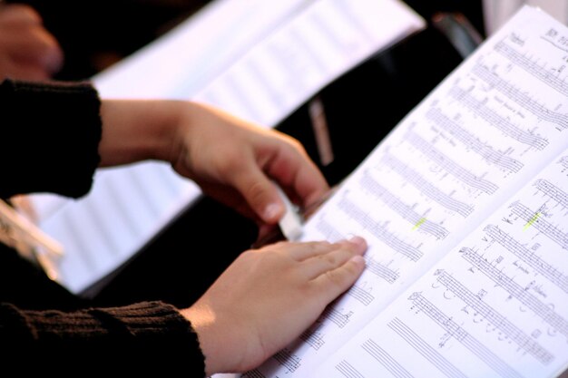 Foto imagem recortada de mãos em folha de música