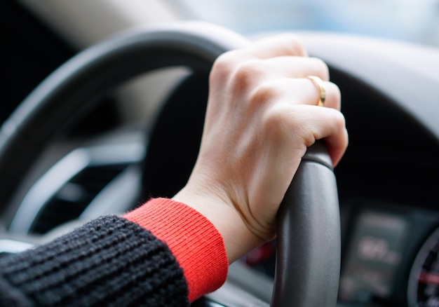 Imagem recortada de mãos no volante de um carro