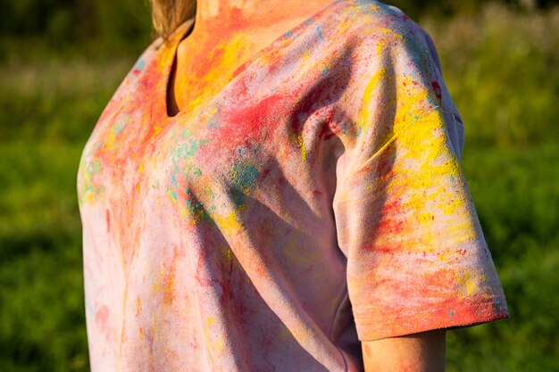 Imagem recortada de mulher de camiseta coberta de tinta em pó colorida holi