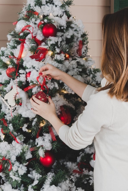 Imagem recortada de mulher decorando árvore de Natal