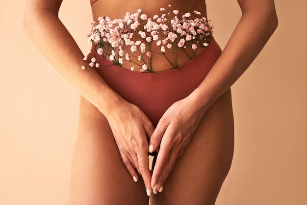 Imagem recortada de mulher em lingerie com flores feitas de calcinhaSaúde e cuidados femininos