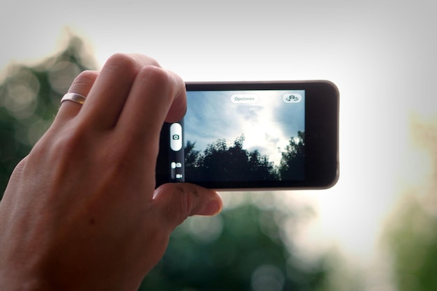 Foto imagem recortada de mulher fotografando através de telefone inteligente