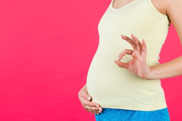 Imagem recortada de mulher grávida com roupas coloridas para casa