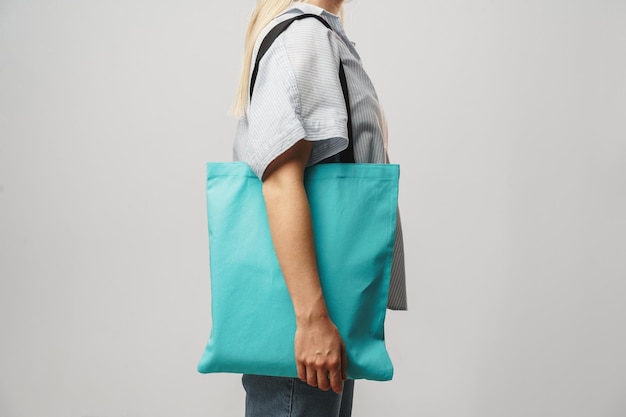 Imagem recortada de mulher segurando uma bolsa de compras colorida no estúdio