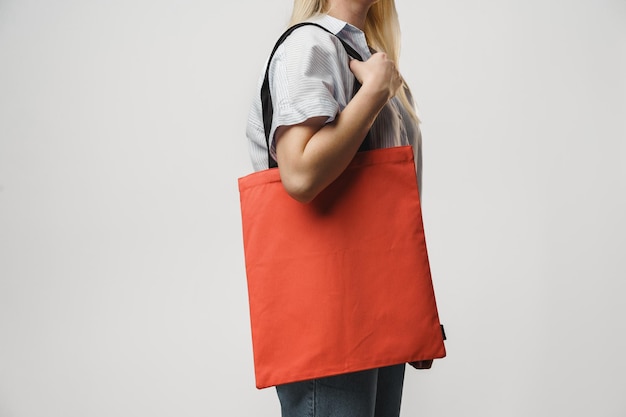 Imagem recortada de mulher segurando uma bolsa de compras colorida no estúdio