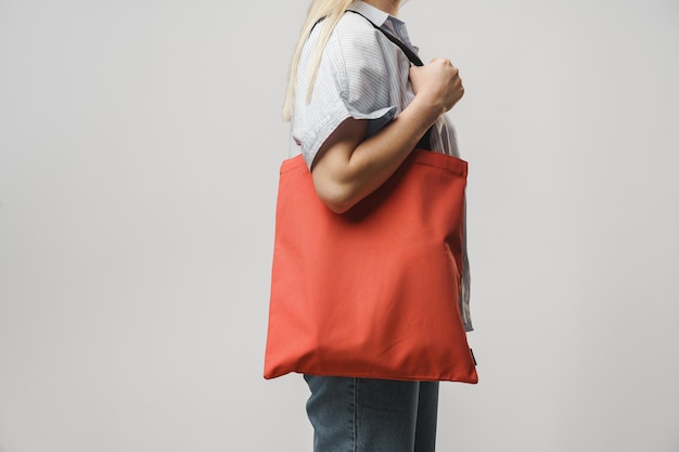 Imagem recortada de mulher segurando uma bolsa de compras colorida no estúdio
