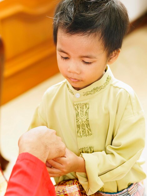 Foto imagem recortada de pai segurando a mão do filho em casa