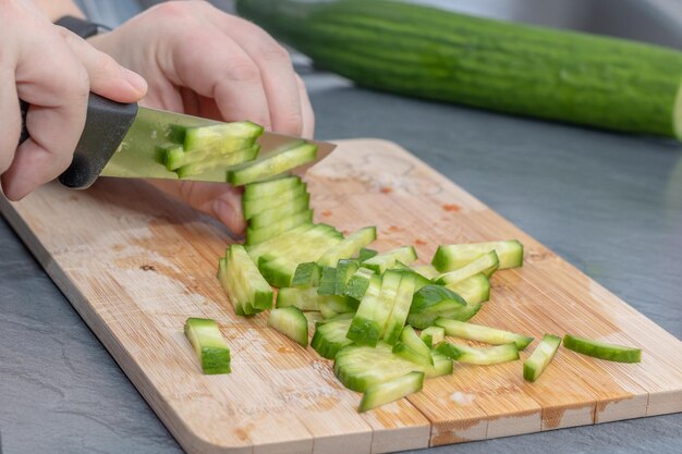 Imagem recortada de pessoa preparando comida na prancha de corte