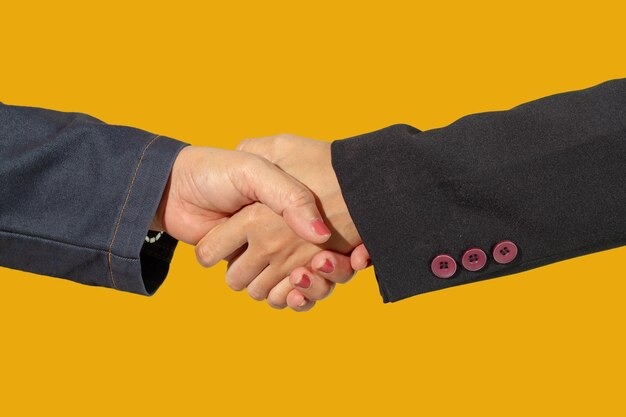 Imagem recortada de pessoas de negócios apertando as mãos contra um fundo amarelo
