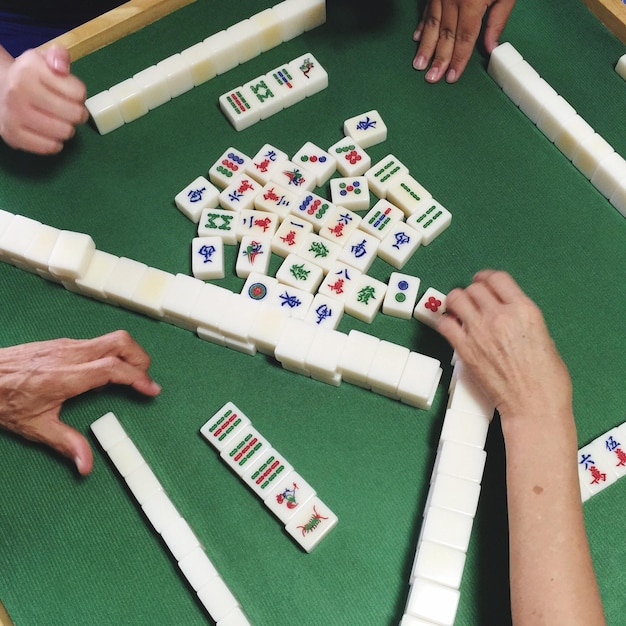 Foto imagem recortada de pessoas jogando mahjong na mesa