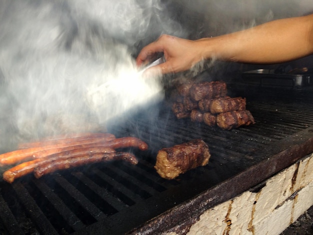 Imagem recortada de salsichas cozinhadas à mão em churrasco